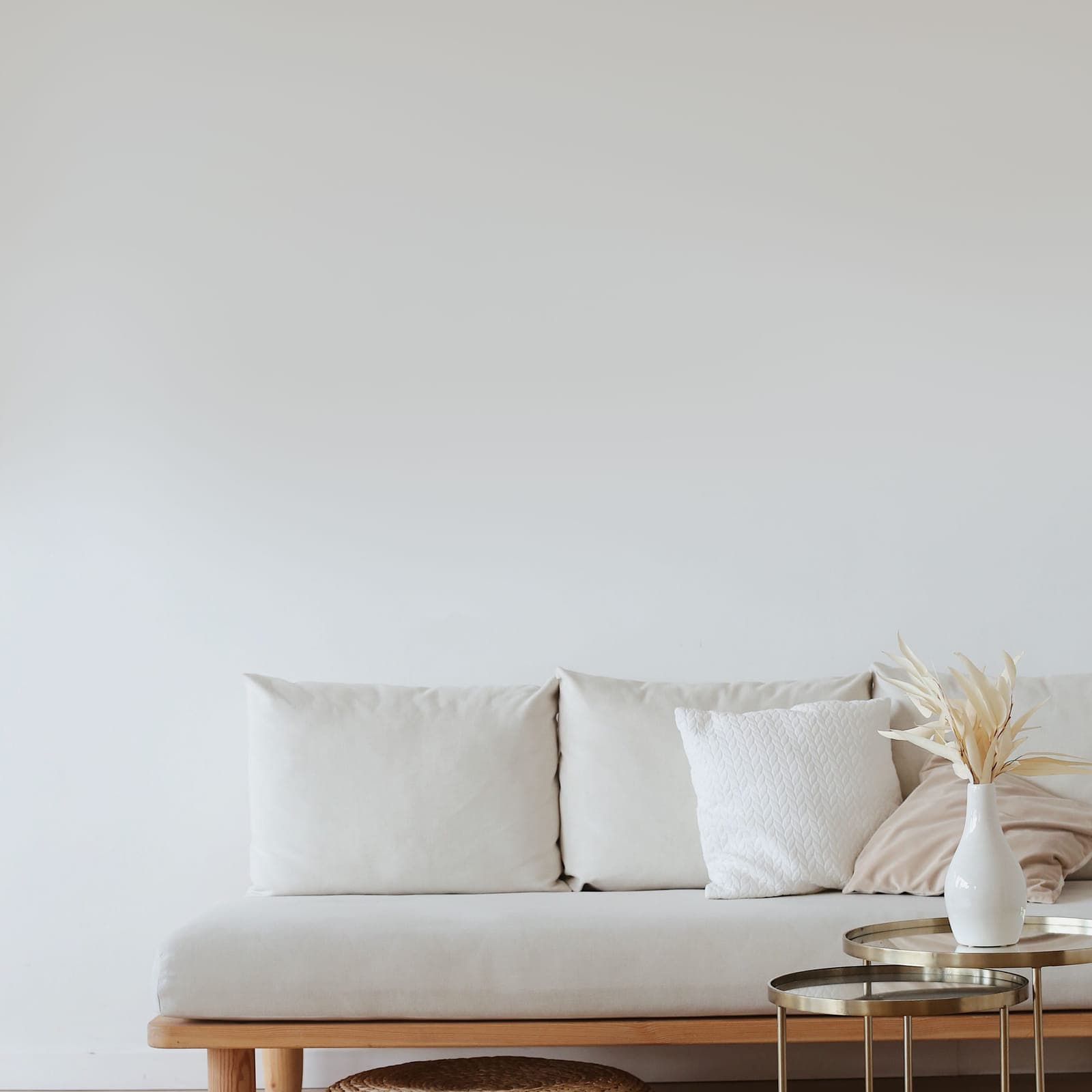 Tyler on a white wall above a low linen sofa